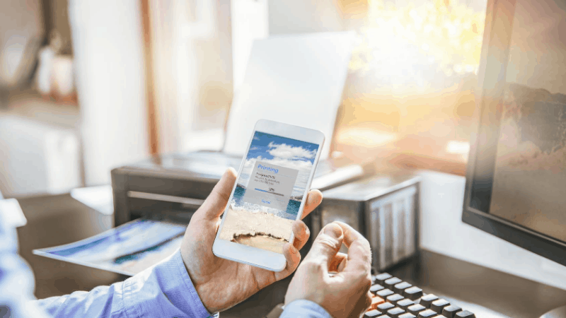 Man using phone to wireless printing from phone to printer