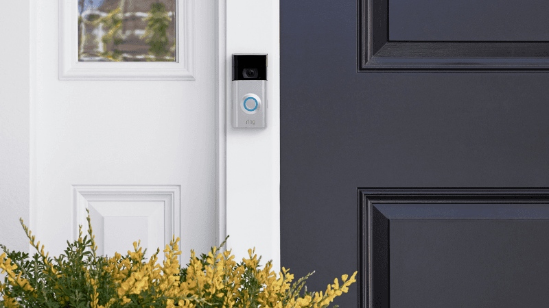 Ring doorbell with blue light outside home with navy door