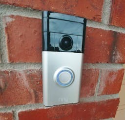 Ring video doorbell installed on red brick home