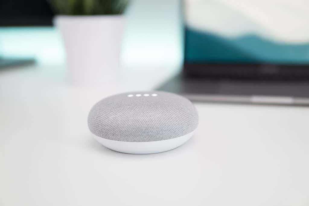 Google Home on white counter with laptop in the background