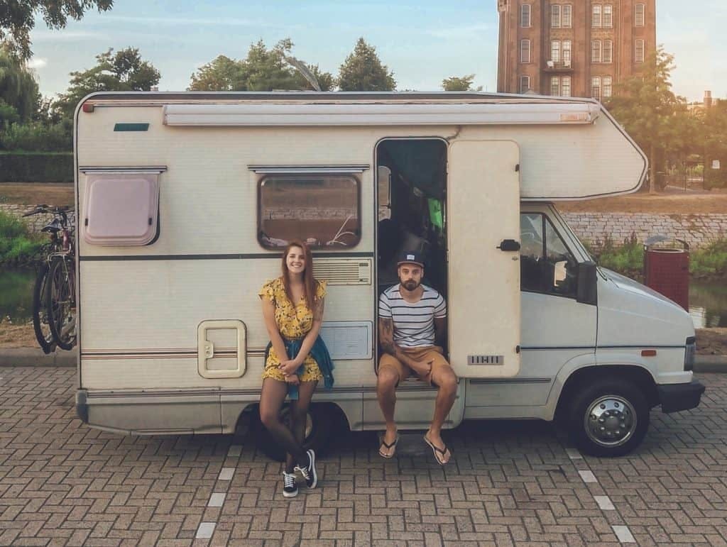 Couple sitting outside their RV.