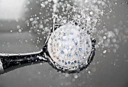 Black shower head spraying water