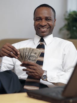 Happy man holding up a bunch of cash