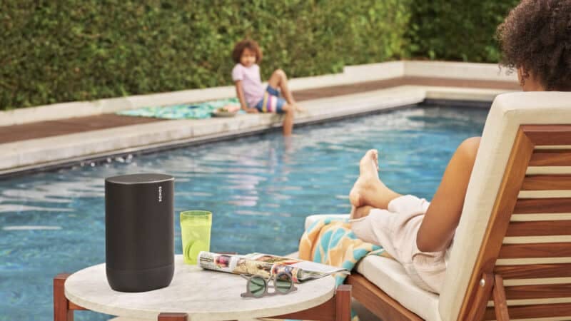 Family enjoying pool with the sonos five speaker on table.