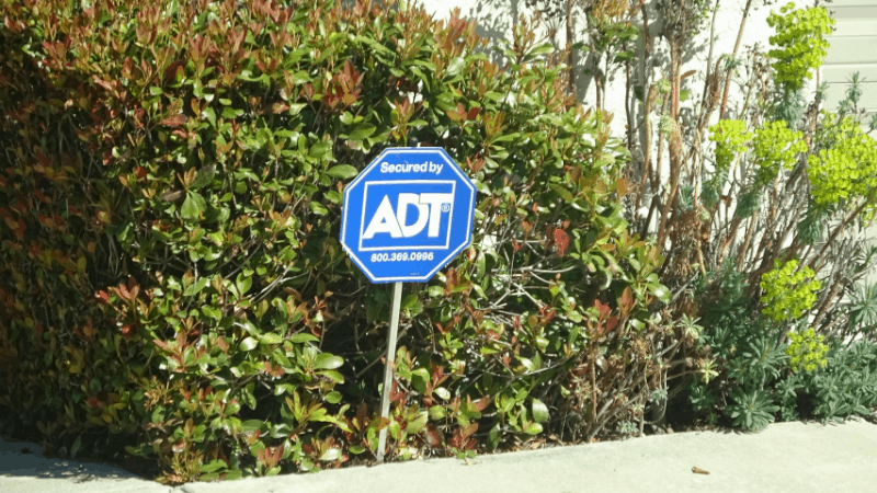 ADT sign in front of bushes