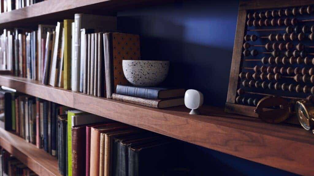 ecobee sensor sitting on brown bookshelf.