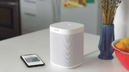 Sonos Air Play 2 sitting on kitchen counter with smartphone.