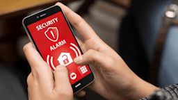 Person on a smartphone on a security alarm app.