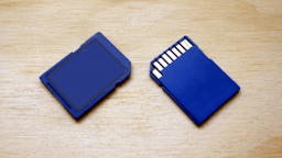 2 Blue SD cards laying on table.