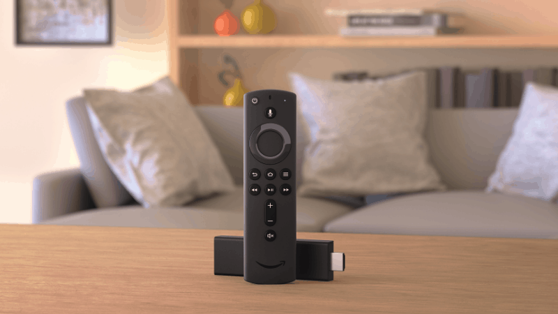 Fire Stick remote with the HDMI device on a table inside a living room.