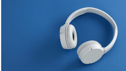 White bluetooth headphones on a blue table.