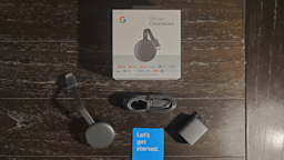 chromecast with plug, adapter, and smartphone on the desk