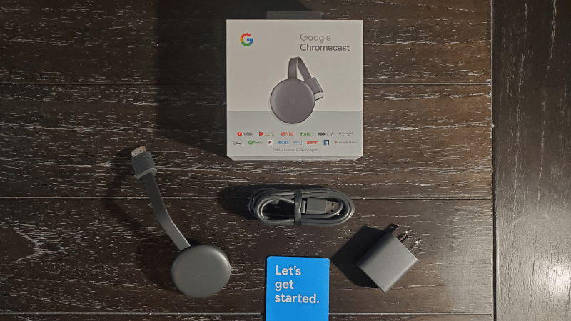 chromecast with plug, adapter, and smartphone on the desk