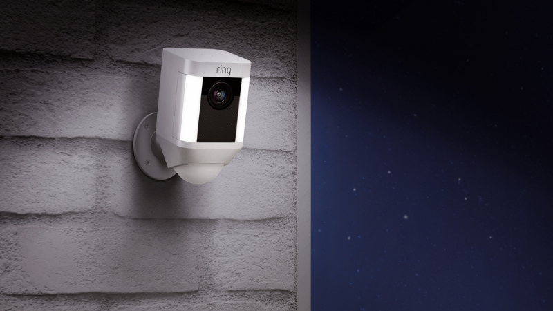 ring spotlight camera installed outside home at night.