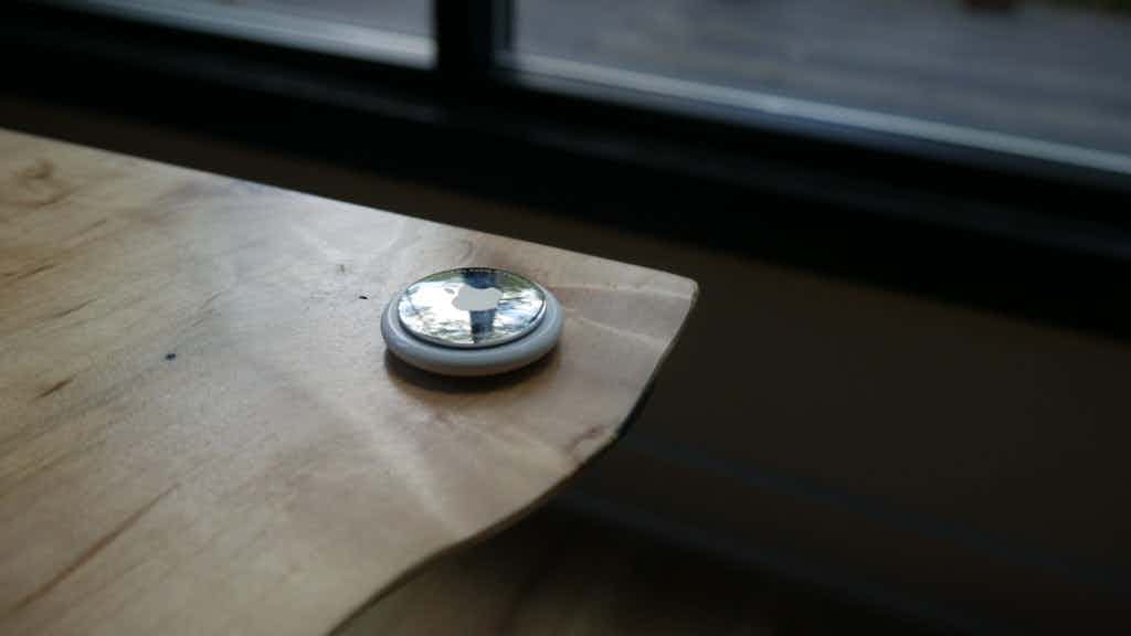 Apple airtag on wooden desk