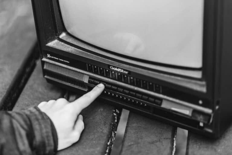 A person turning on an old TV in black and white