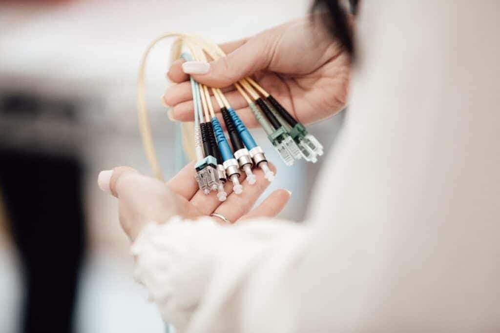 person holding a variety of audio cables