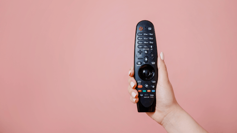 lg tv remote being held by a women hands