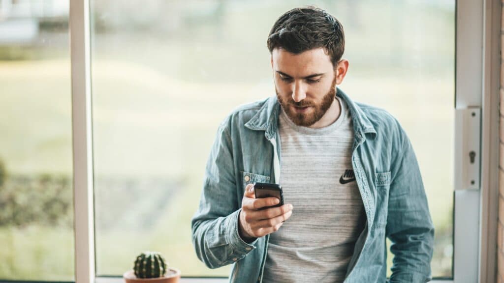 man looking at his smart phone outside