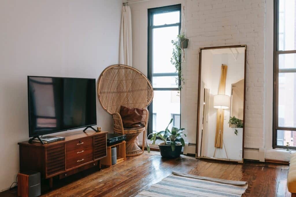 Living room with tv, woven chair, and mirror