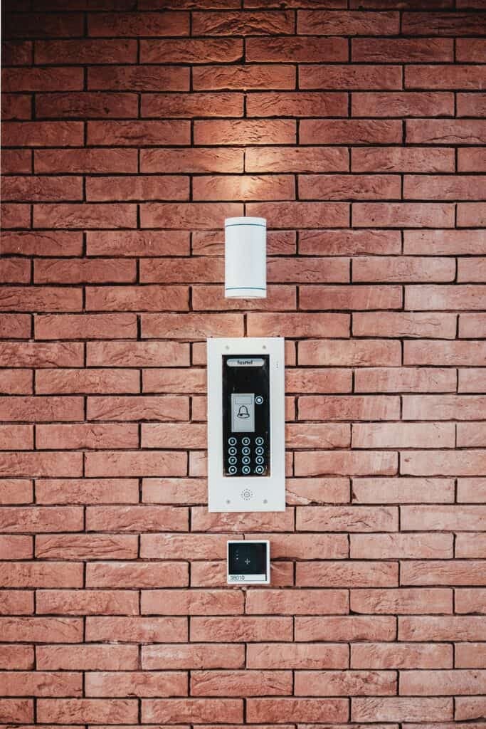 Red brick wall with doorbell display and numberpad