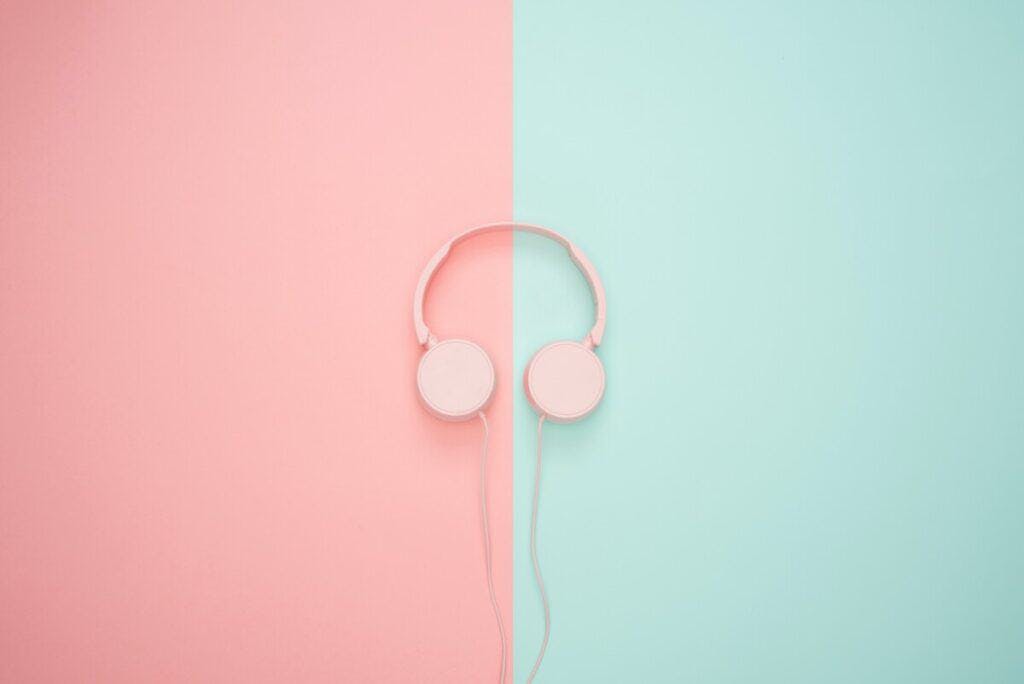 pink headphones on a half pink, half mint green background