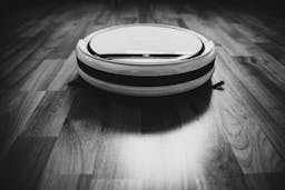 A white and black smart vacuum Roomba i7