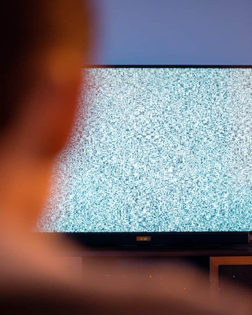 person watching tv with static on screen