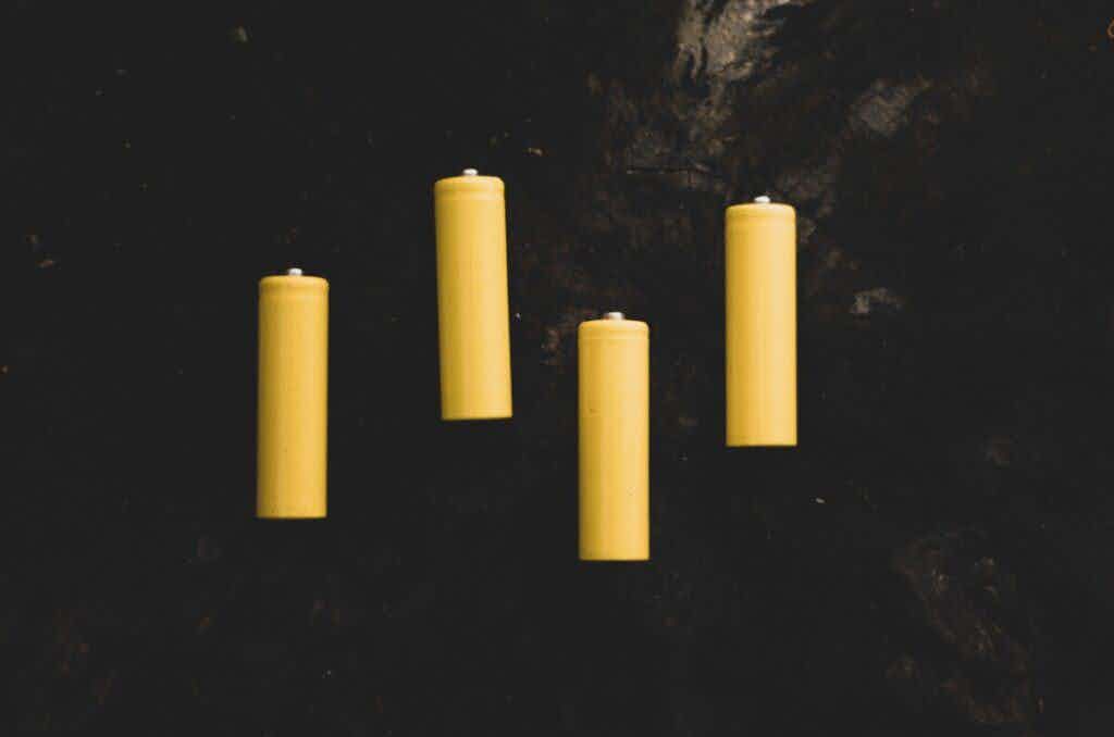 four yellow batteries on a black background