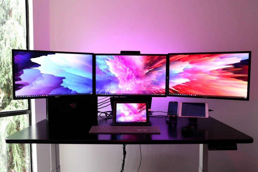 three monitors and a laptop