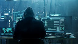 hacker looking at computer screens