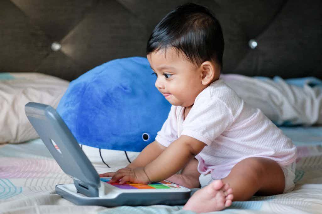 Baby looking at a toy laptop