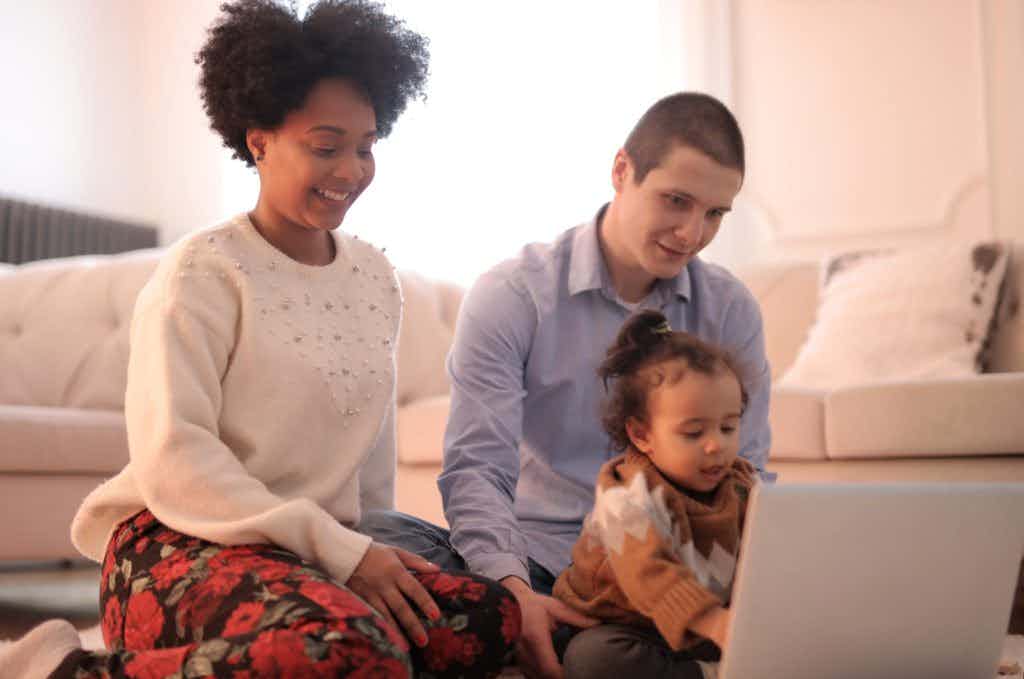 A family on the computer with the baby at the keyboard.