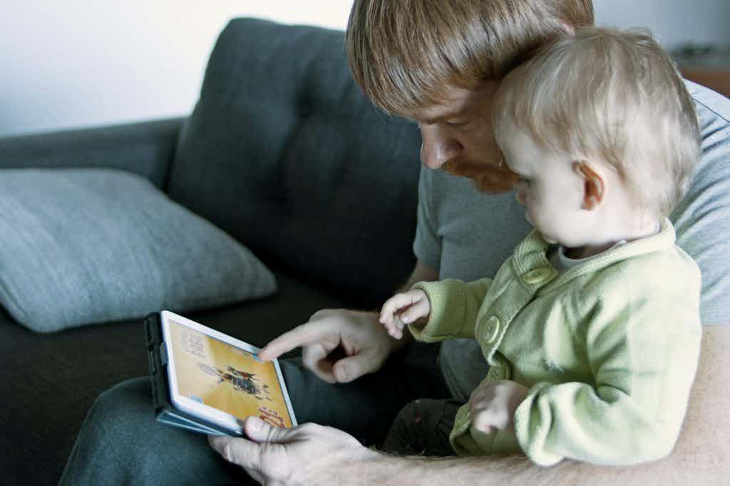 Adult and baby looking at a screen