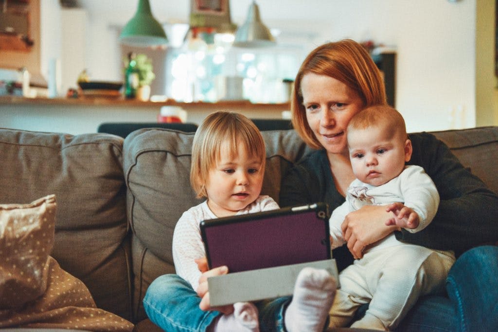 parent and children watching tablet