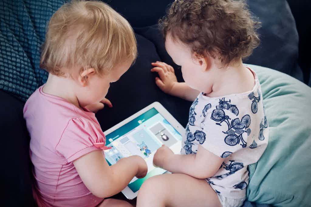Two babies using a tablet