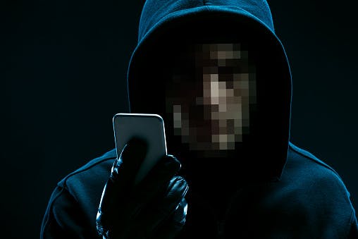 hacker-Portrait of unrecognizable hacker with smartphone