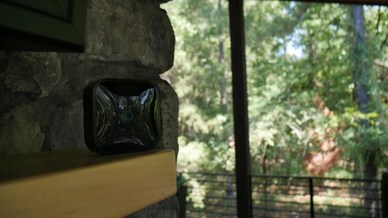 A Blink Outdoor Camera on a ledge outside.