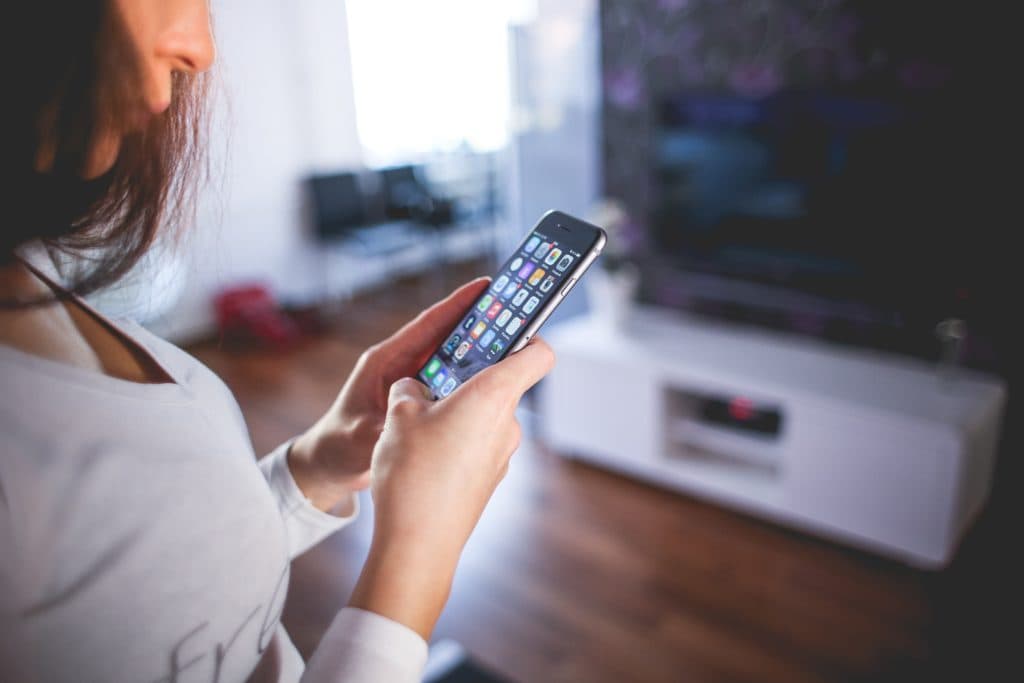 A woman opening up the app on her phone to change the WiFi on her Yi Home Camera.