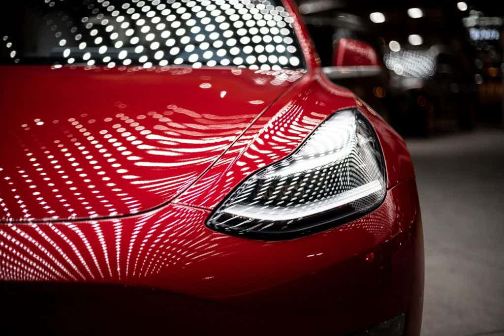 Red Tesla with a bunch of spotlights on it