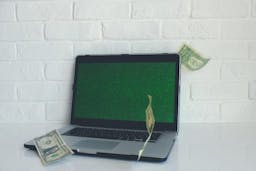 Green screen laptop with money falling around it