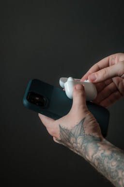 Airpods being put into case with an iphone