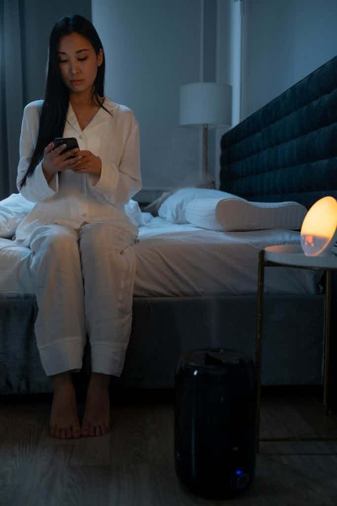 A woman using her smart phone with humidifier