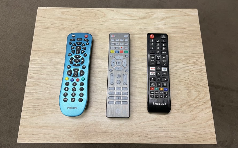 3 TV Remotes on wood desk